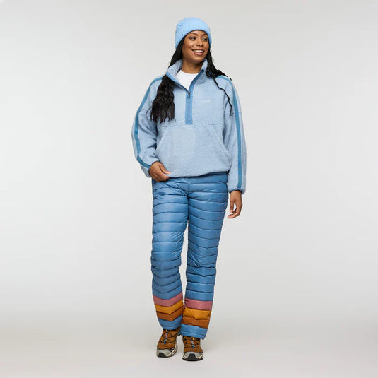 Person wearing a blue fleece jacket and puffer pants with colorful accents on a white background