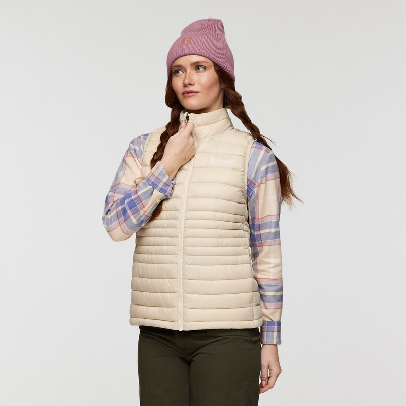 Load image into Gallery viewer, Woman wearing a beige puffer vest, plaid shirt, and pink beanie on a light gray background

