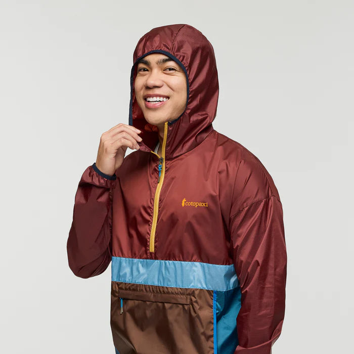 Load image into Gallery viewer, Person wearing a maroon and blue hooded jacket with a cotopaxi logo on a light gray background
