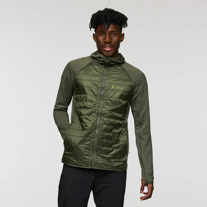 Person wearing a green jacket with a brand logo on a gray background