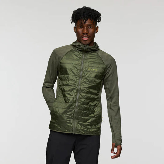 Person wearing a green jacket with a brand logo on a gray background