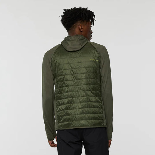 Person wearing a green quilted jacket on a light gray background