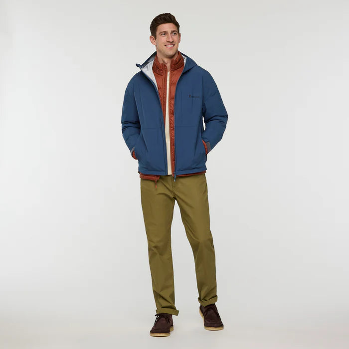 Load image into Gallery viewer, Man wearing a blue cotopaxi zip rain jacket with a red interior, green pants, and brown shoes on a white background
