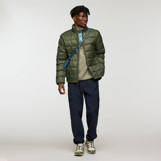 Man wearing a green puffer jacket with a white background
