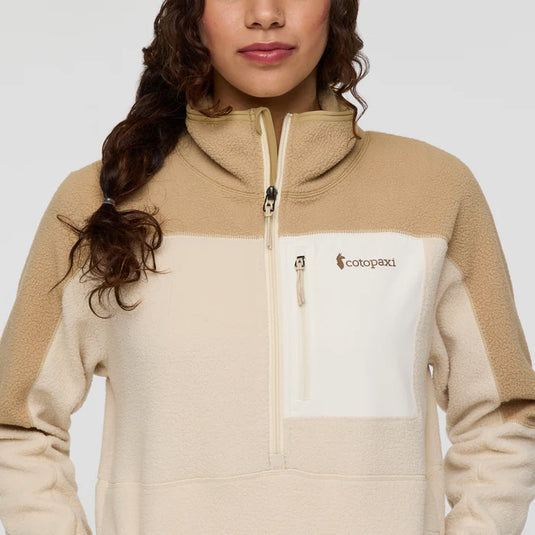 Person wearing a beige and white fleece jacket with Cotopaxi logo on a white background