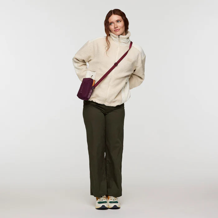 Load image into Gallery viewer, Woman wearing a cream jacket and dark pants with a purple bag on a white background

