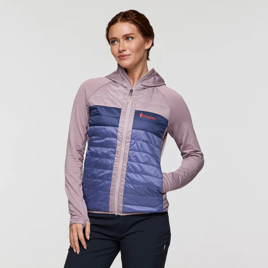 Woman wearing a two-tone jacket with a visible brand logo on a light gray background