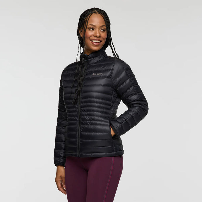 Woman wearing a black puffer jacket on a light gray background