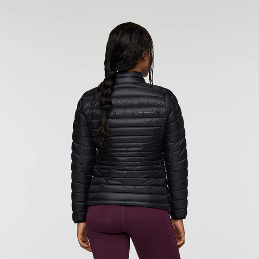 Person wearing a black puffer jacket on a light gray background