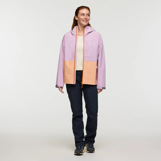 Woman wearing a two-tone jacket with pink and beige sections on a white background