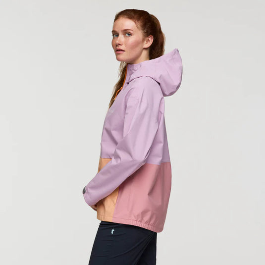 Woman wearing a two-tone pink and purple jacket on a light gray background