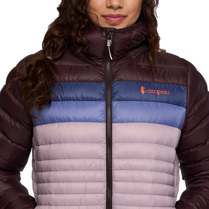 Load image into Gallery viewer, Person wearing a multicolored puffer jacket with a Cotopaxi logo on a white background
