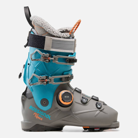 Load image into Gallery viewer, A Rossignol Alltrack ski boot in gray and turquoise blue, featuring a gray shell, a turquoise plastic shroud, a gray BOA dial, and a gray fleece lining with an orange pull tab, shown against a light gray background.
