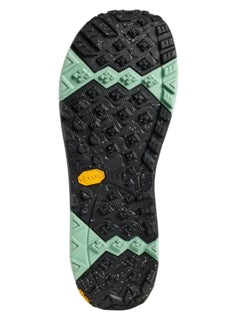 Black and green sole of a shoe with a yellow tag on a white background.