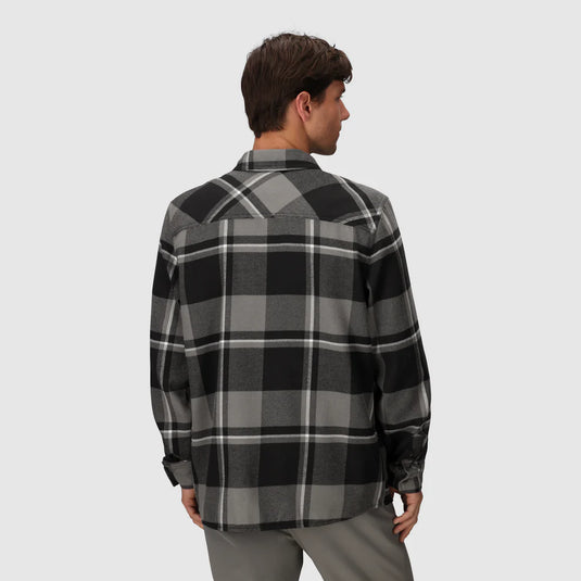 Person wearing a black and gray plaid shirt on a light gray background