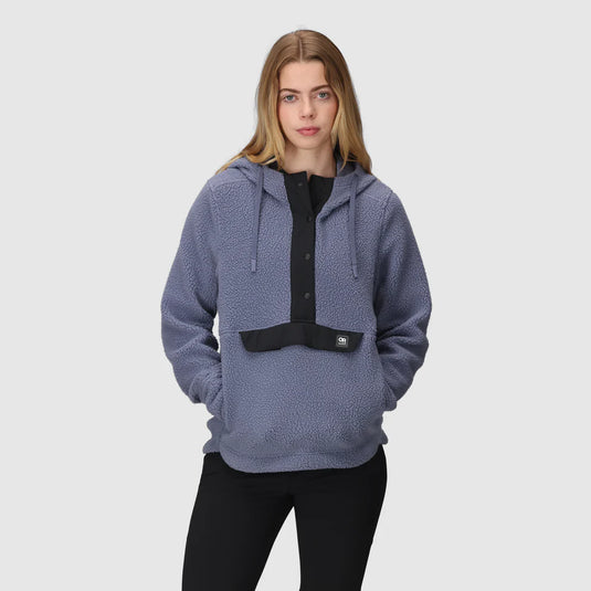 Woman wearing a blue textured hoodie on a light gray background