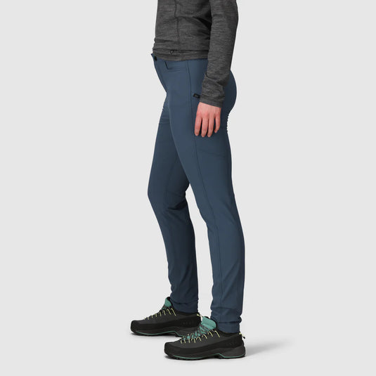 Person wearing blue pants and black shoes on a light gray background