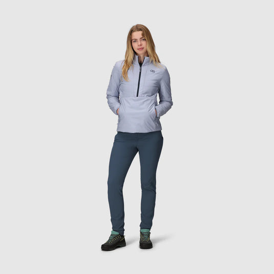 Woman wearing a light gray jacket and dark blue pants on a white background