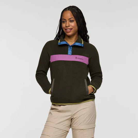 Woman wearing a dark green pullover with a purple stripe on a white background