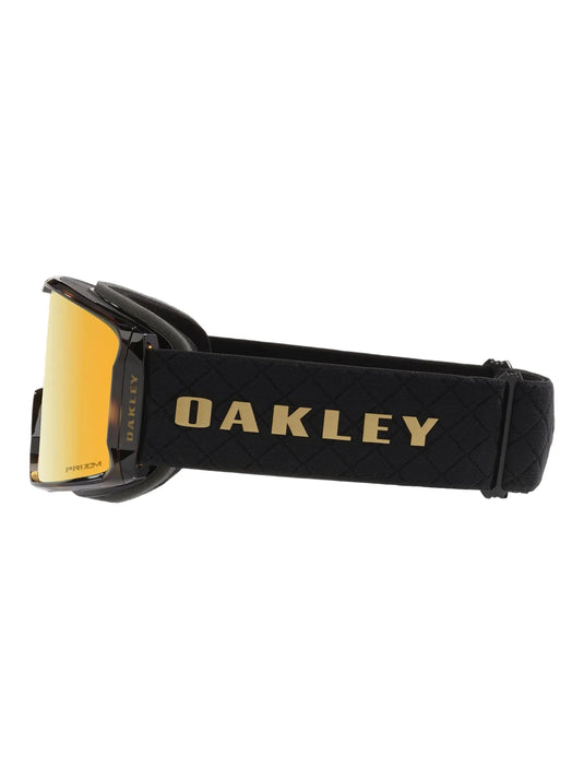 Oakley ski goggles with a black frame and strap, featuring a gold mirrored lens and gold OAKLEY branding on the strap.