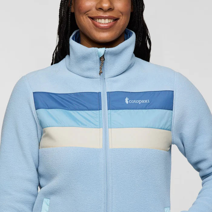 Load image into Gallery viewer, Person wearing a light blue jacket with color-block design and Cotopaxi logo.
