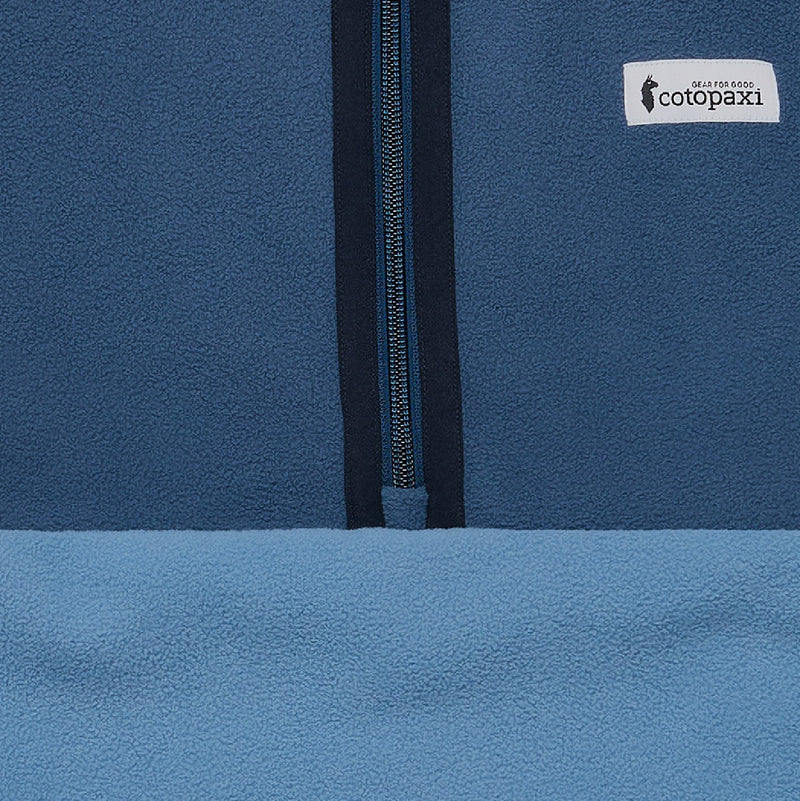 Load image into Gallery viewer, Close-up of a blue jacket with a zipper and Cotopaxi logo.
