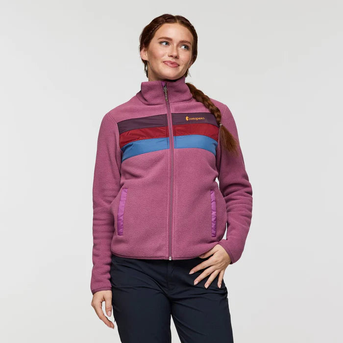 Load image into Gallery viewer, Woman wearing a purple fleece jacket with a Cotopaxi logo on a light gray background
