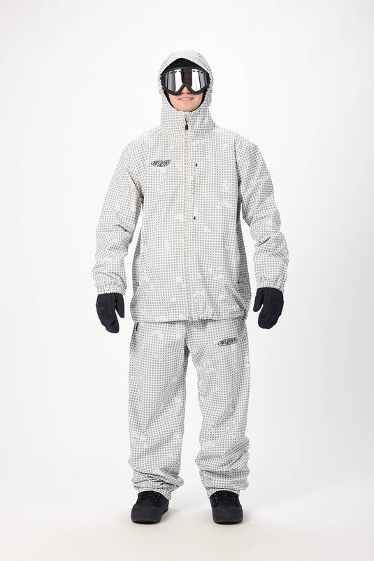 A person modeling a light gray and white checkered Airblaster snowsuit with the Beast Access jacket and hood. Ski and Tennis Station