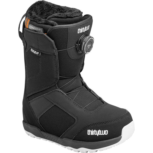 A black thirtytwo snowboard boot with a BOA dial closure system, featuring a white and black sole and a soft fleece lining visible at the collar. Ski and Tennis Station.