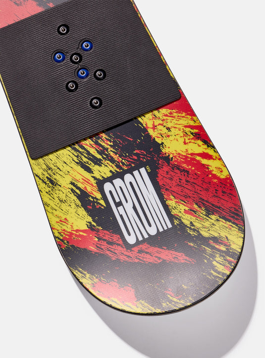 Snowboard with colorful abstract design and 'GROM' branding on a white background