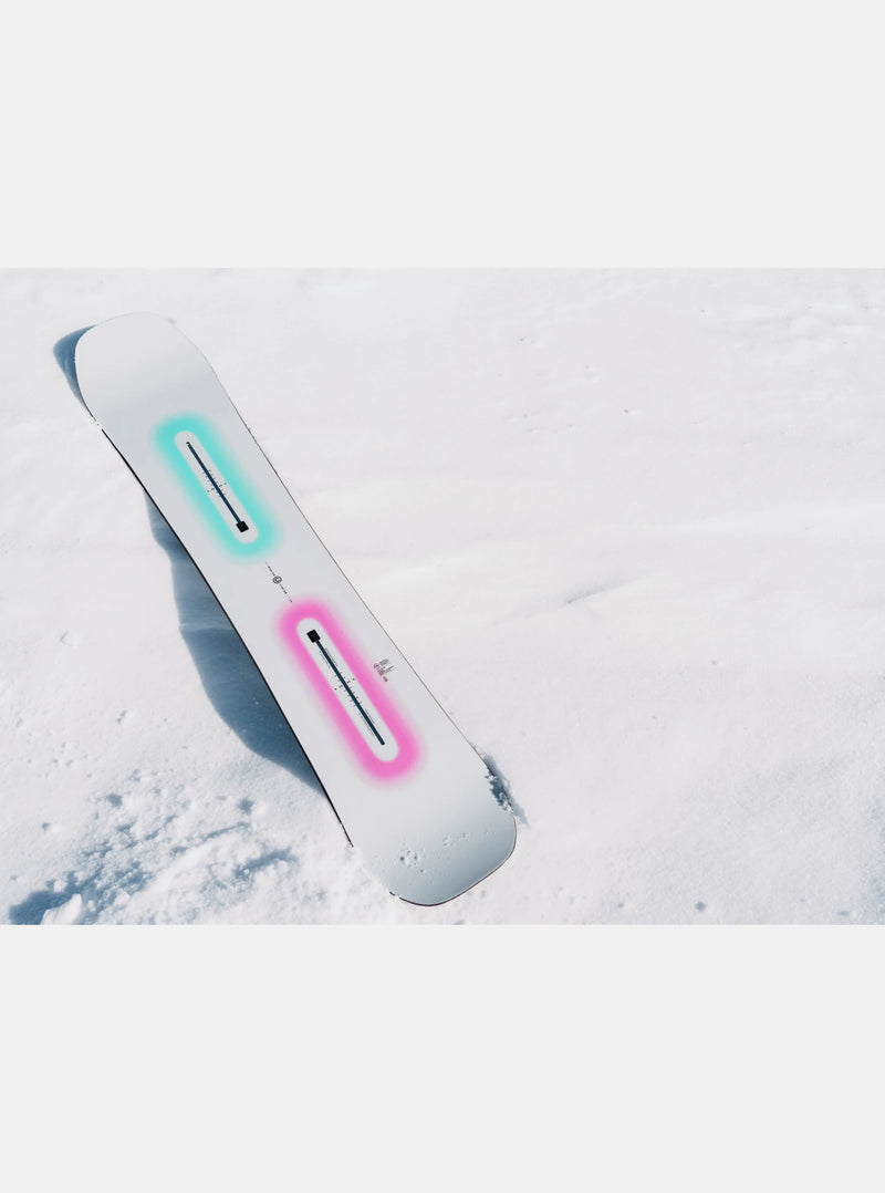 Load image into Gallery viewer, Snowboard with colorful accents on a snow-covered surface
