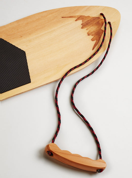 Wooden snowboard with black and red rope on a light background