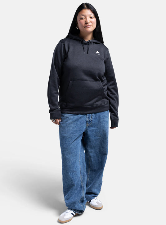 Woman wearing a black Burton hoodie and blue jeans on a white background