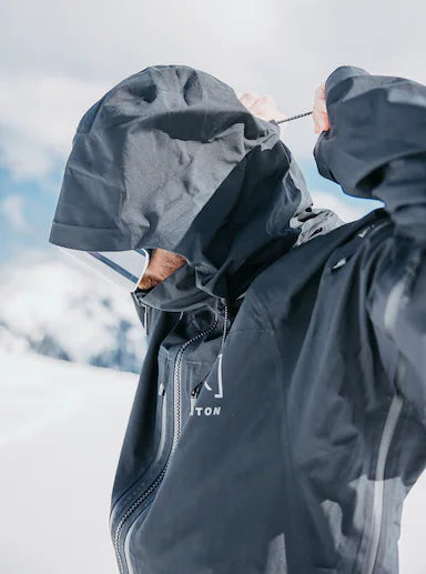 Load image into Gallery viewer, Man making Burton hood adjustment in a snowy landscape
