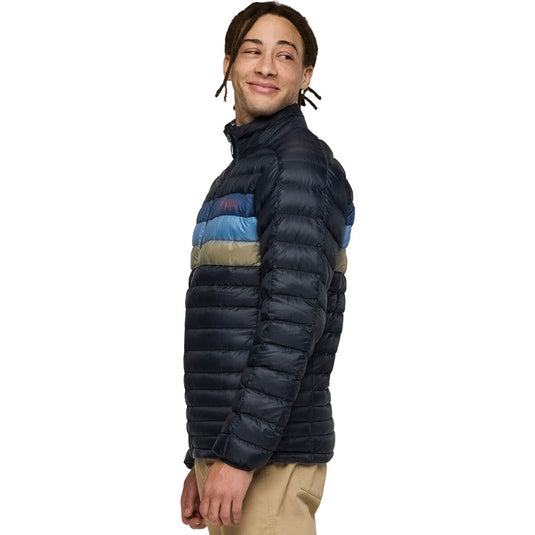Man wearing a blue puffer jacket with blue and beige accents on a white background