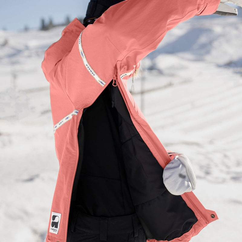 Load image into Gallery viewer, Person wearing a pink jacket with a brand logo in a snowy landscape
