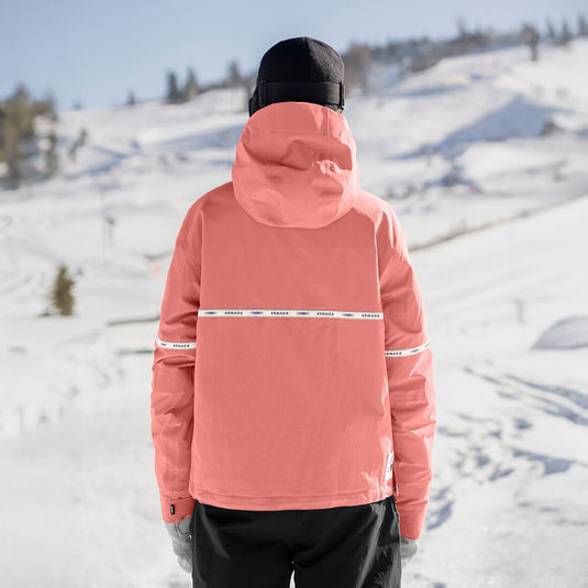 Person wearing a pink jacket with visible branding in a snowy landscape