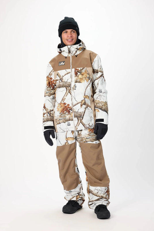 Person wearing an Airblaster camouflage snowsuit featuring the Guide shell jacket. Ski and Tennis Station