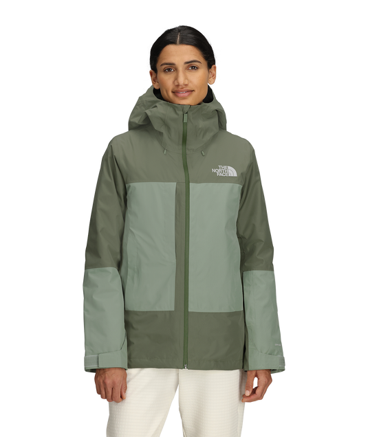Woman wearing a green and gray jacket with The North Face logo on a white background