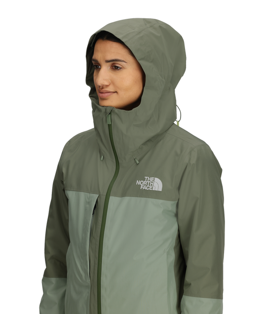 Person wearing a green jacket with The North Face logo on a white background
