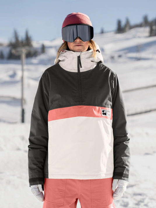 Person wearing a colorful jacket and goggles on a snowy slope