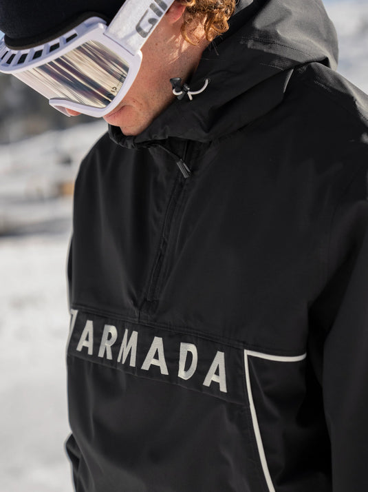 Person wearing a black jacket with 'Armada' branding in a snowy setting