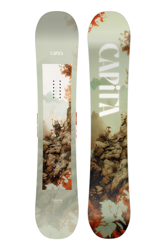 A CAPiTA snowboard shown from both sides against a plain white background. The left side features a light sage green base with a central graphic of a skier on a mountain, and the right side features a matching mountain and rock graphic in earthy tones with large white CAPiTA lettering.