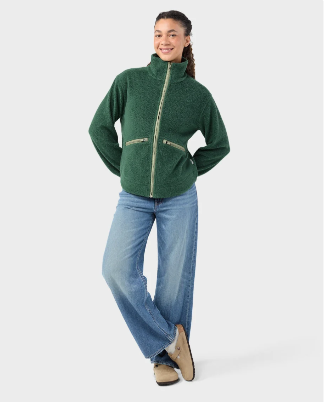 Load image into Gallery viewer, A woman modeling a medium green Stio Rawlins fleece jacket with a high collar, full-length front zipper, and two zippered hand pockets, Ski and Tennis Station
