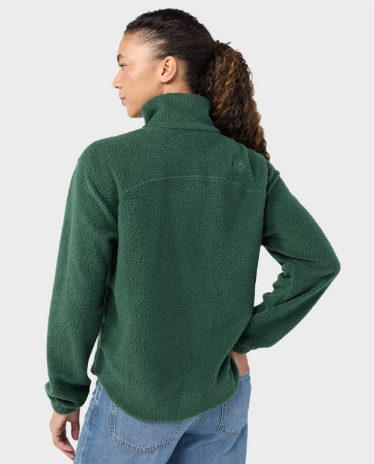 A woman modeling a medium green Stio Rawlins fleece jacket with a high collar, full-length front zipper, and two zippered hand pockets, Ski and Tennis Station