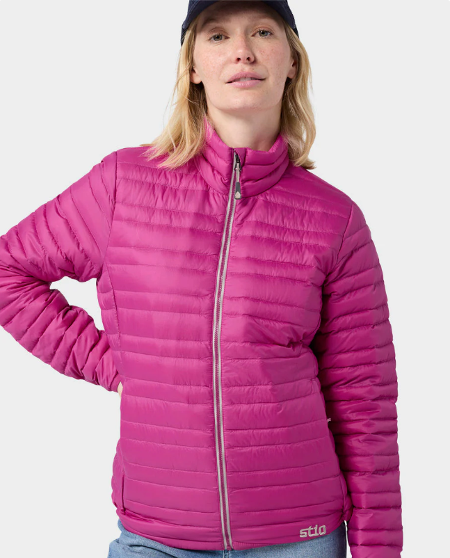 Load image into Gallery viewer, A woman wearing a bright pink Stio puffer jacket with a high collar and front zipper. Ski and Tennis Station
