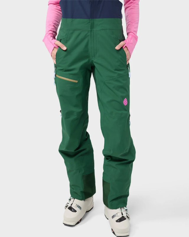 Load image into Gallery viewer, A pair of dark green Stio ski bib pants with a navy blue chest panel, gray adjustable suspenders. Ski and Tennis Station
