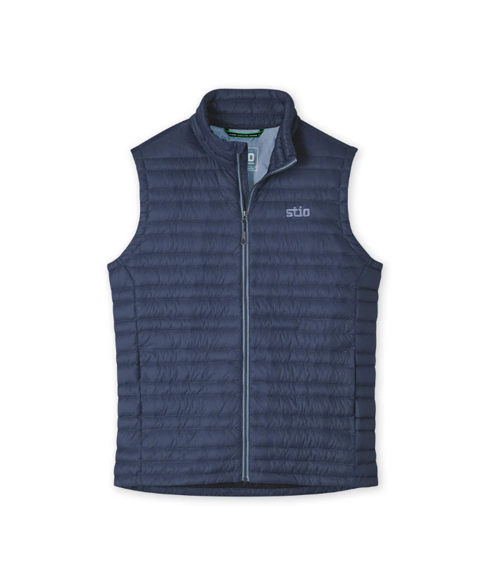 Load image into Gallery viewer, A navy blue Stio puffer vest with a full-zip front and stand-up collar, shown flat against a white background. Ski and Tennis Station
