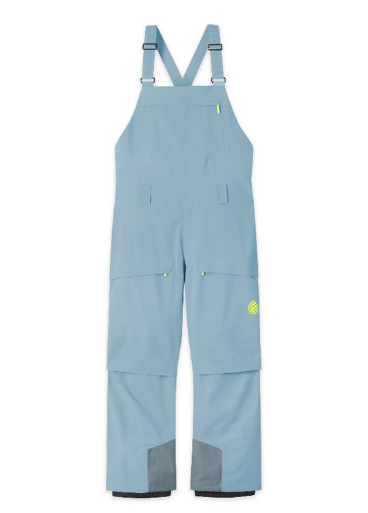 Light blue snow bib overalls from Stio with adjustable shoulder straps, multiple utility pockets, and gray reinforced knee and ankle panels, shown flat against a white background. Ski and Tennis Station