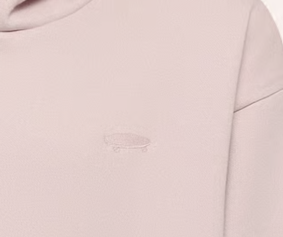 Load image into Gallery viewer, Close-up of a light blush pink sweatshirt featuring a small, tonal embroidered skateboard logo on the chest.
